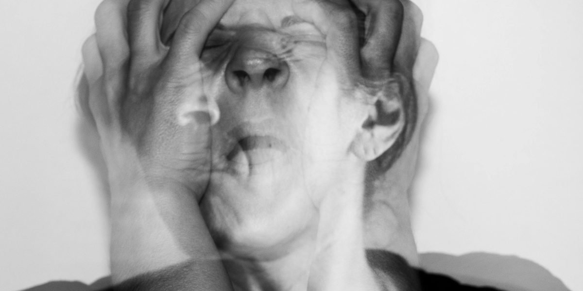 A person showing signs of physical anxiety, such as a hand on the chest, to represent the body's reaction to phobic triggers.