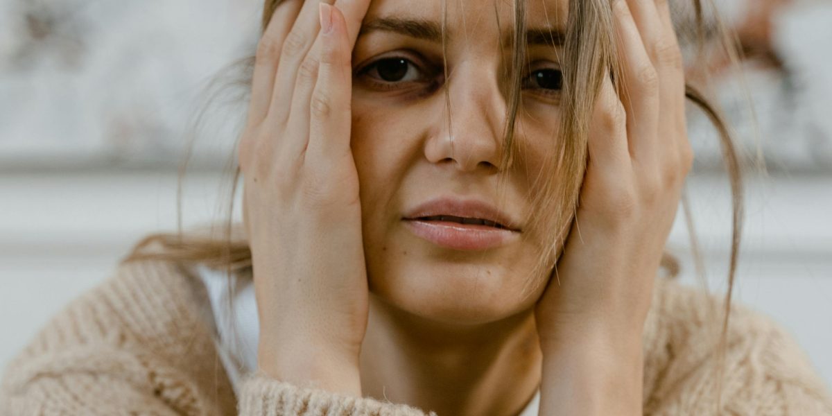 A person appears deep in thought, perhaps feeling overwhelmed or trying to process complex information, reflecting the internal experience of schizophrenia.