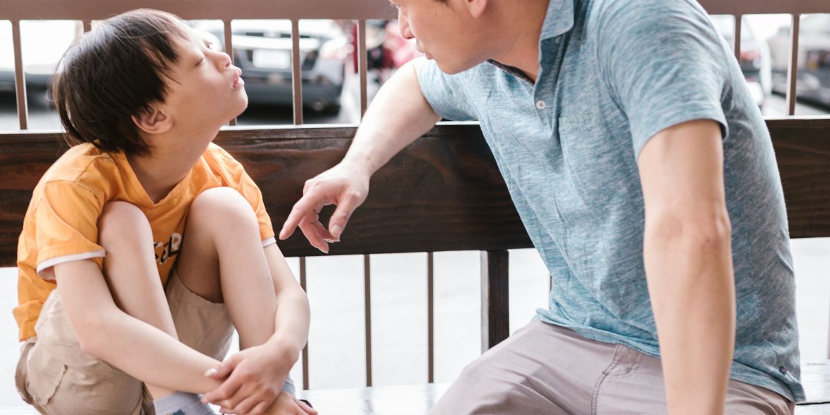 A parent attentively listening to a child, conveying the often confusing and exhausting experience of dealing with a child's severe emotional outbursts.