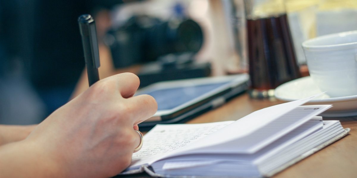 A person thoughtfully reviewing notes or a journal, symbolizing the process of monitoring progress and planning for long-term health management.