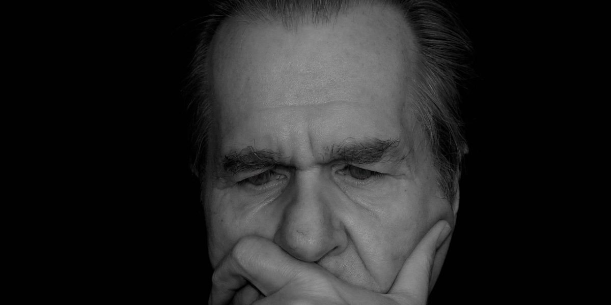A person deep in thought, reflecting on feelings of distrust and the challenge of building trust.