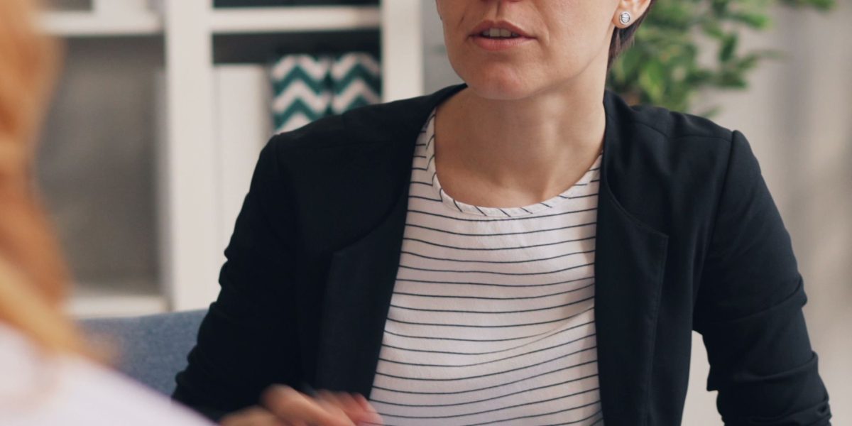 A person engaged in a calm and supportive conversation with a therapist in a professional office setting.