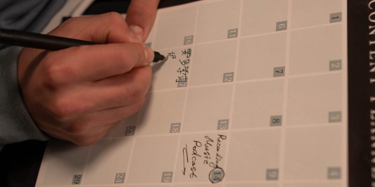 A person focused on writing in a notebook or planner, representing the active process of building a personal safety plan.