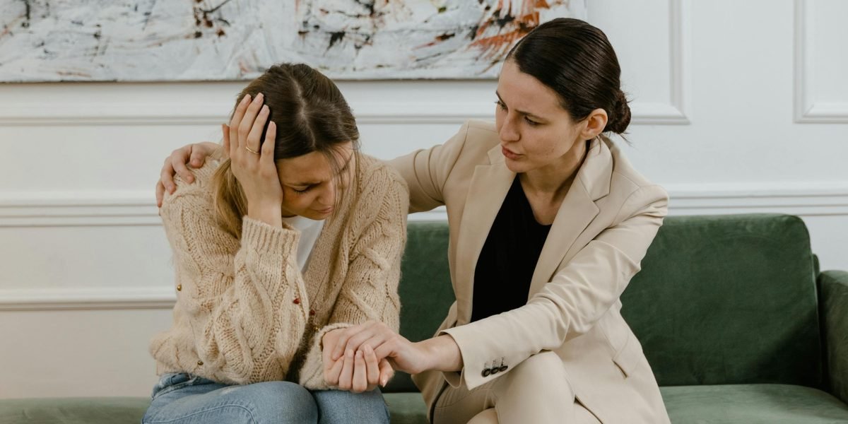 Two people engaged in a calm, empathetic conversation, one listening actively to the other, symbolizing difficult discussions and support.