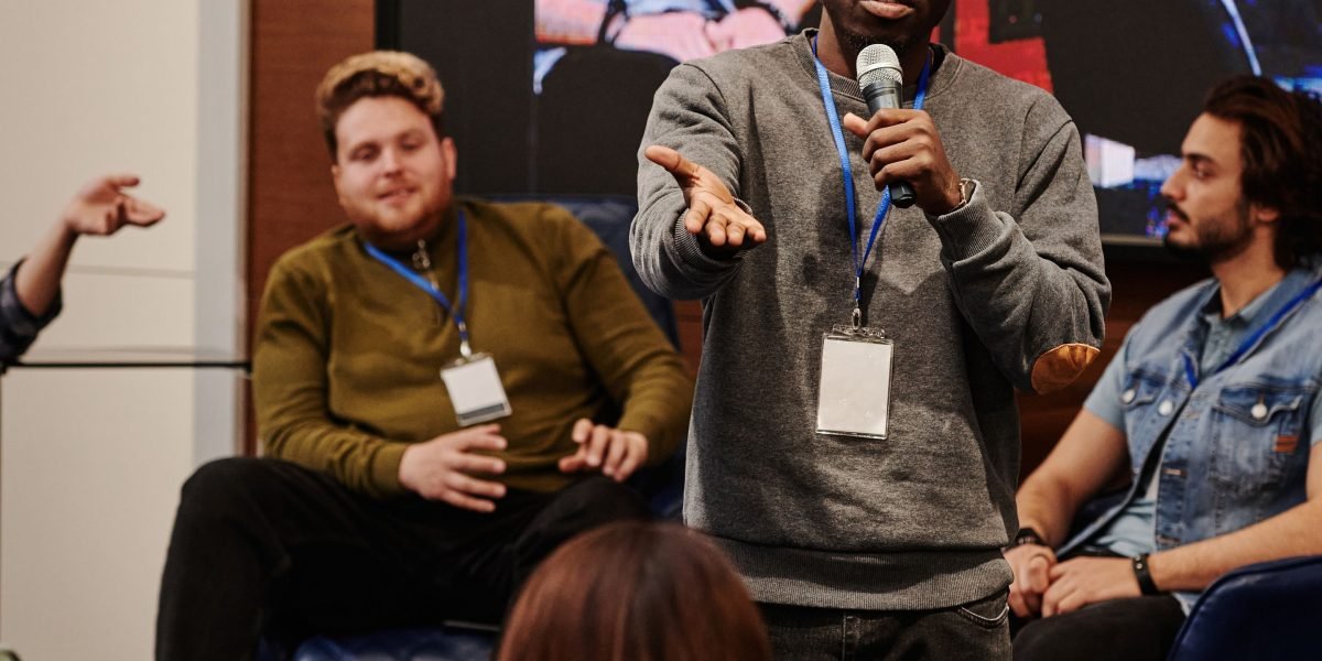 A person confidently engaging in a group discussion or presentation, demonstrating increased self-efficacy in a social setting.
