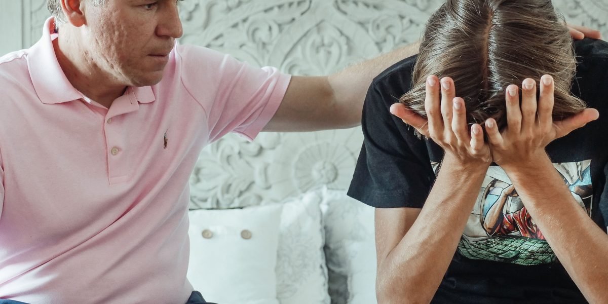 A parent offering comfort and support to their teenager, showing emotional connection.