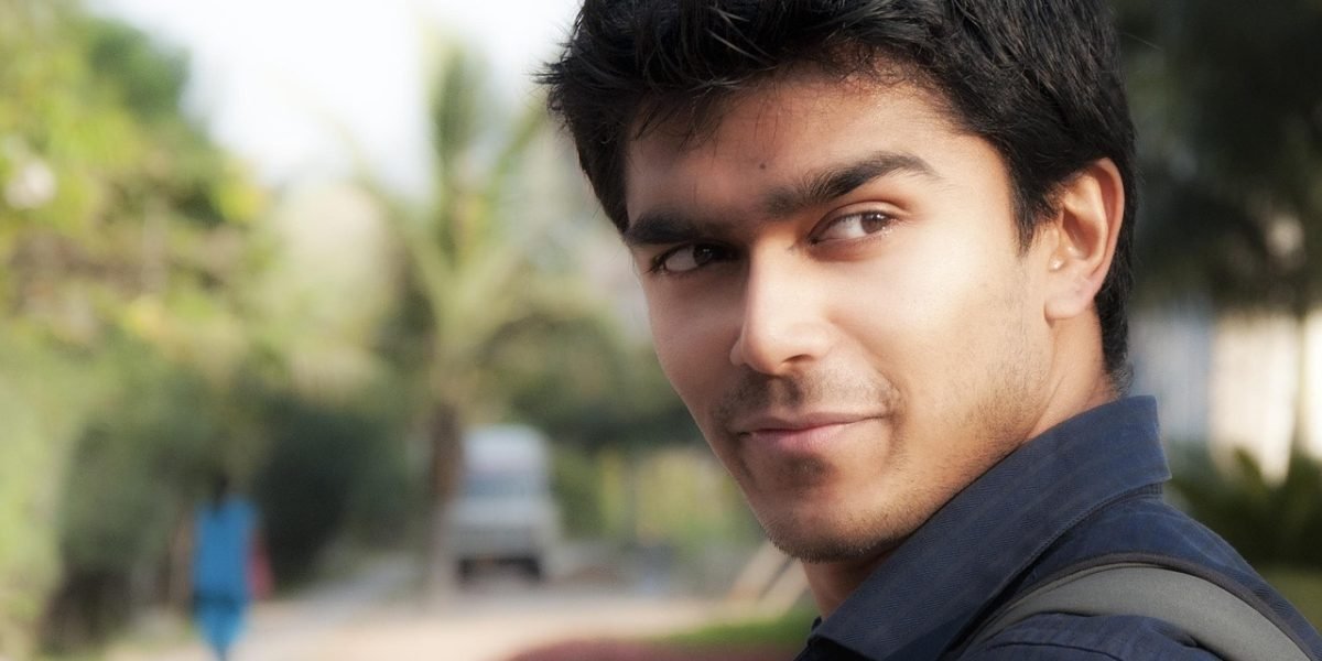 A confident person smiling outdoors, representing successful management and stability in living with bipolar disorder.