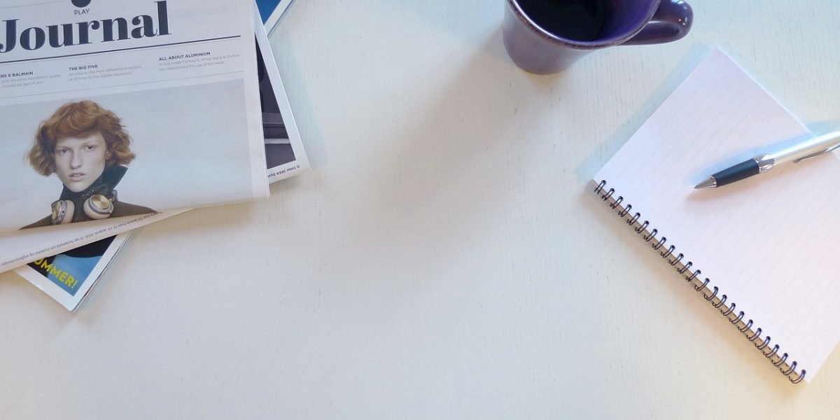 An individual writes in a journal, representing the practice of monitoring personal well-being and progress in mental health journey.