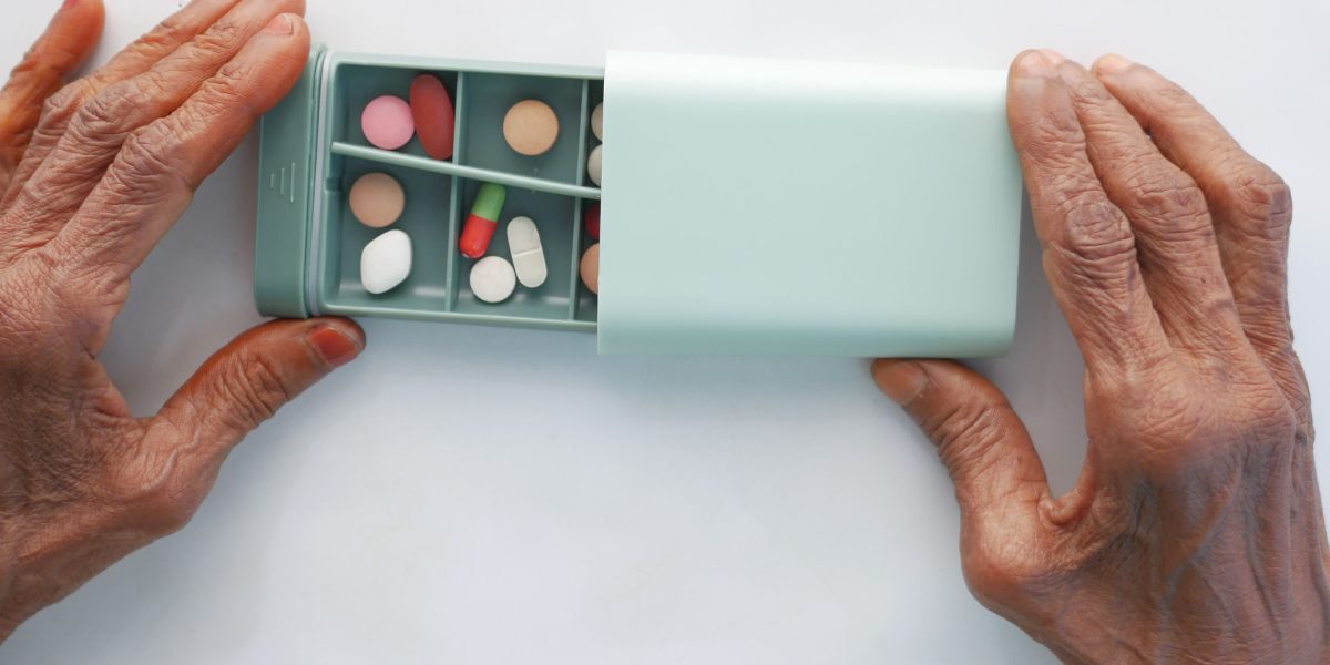 A person organizing daily medication, symbolizing adherence and a structured approach to Bipolar I management.